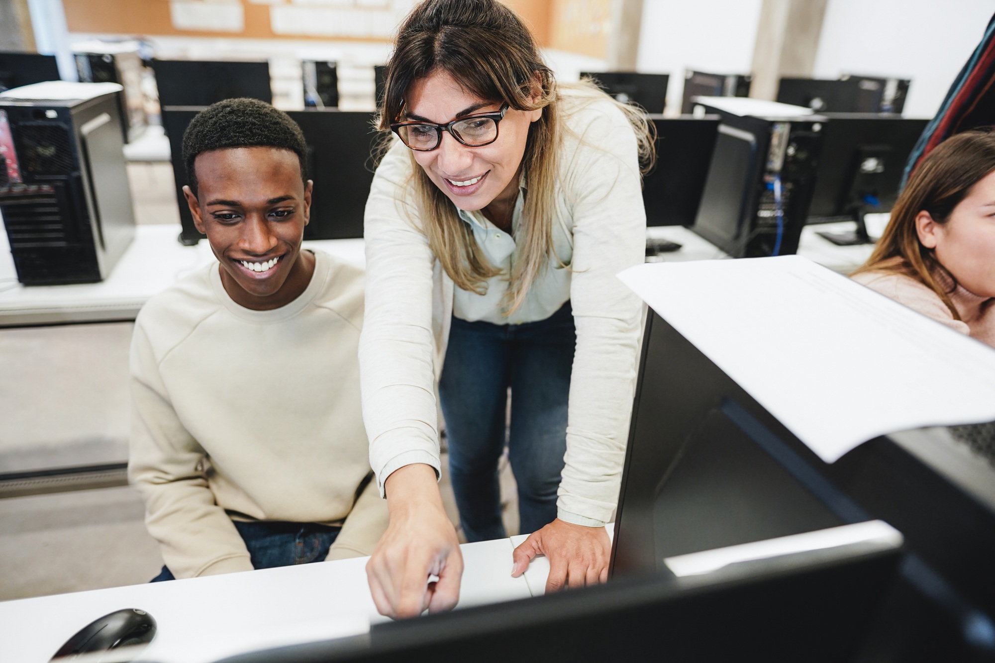 Teacher working with students inside computer class room - Focus on woman face