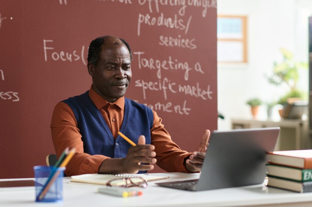 Black college professor sitting at desk