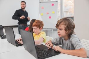 Elementary schoolkids working on laptops in classroom
