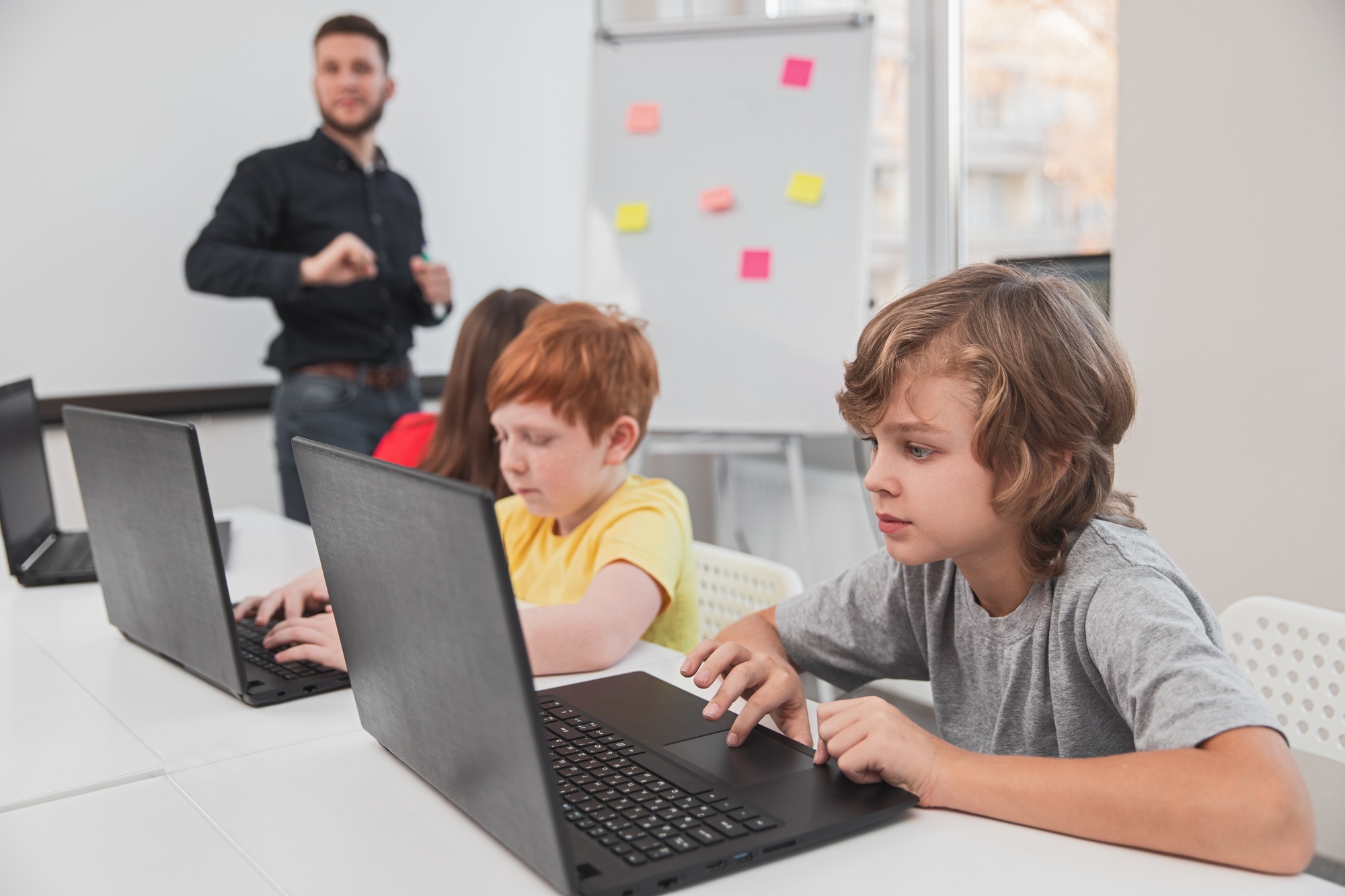 Elementary schoolkids working on laptops in classroom